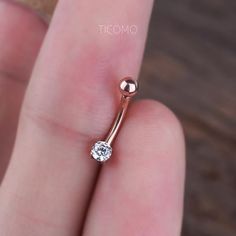 a close up of a person's hand holding a ring with a diamond on it