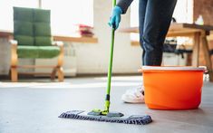 a woman is cleaning the floor with a mop