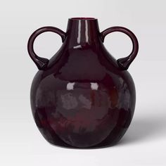 a large red vase with two handles on the top and bottom, sitting in front of a white background