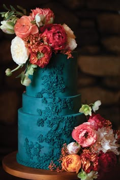 a blue wedding cake with flowers on top