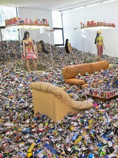 a room filled with furniture and lots of soda cans all over the floor in front of mirrors