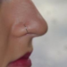 a woman's nose with a tiny ring on the end of her nose,