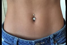 a woman's stomach with a tiny bead in the middle and an earring on it