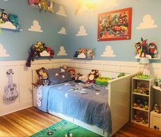 a child's bedroom decorated in blue and white with toy animals on the wall