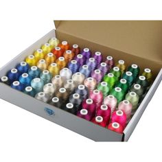 a box filled with lots of spools of thread next to eachother