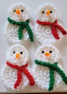 four crocheted snowmen with red and green scarfs on top of each other