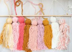 there are many different colors of yarn hanging on the wall