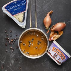 some food that is on top of a black table with spoons and seasonings