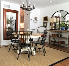 a dining room table with four chairs and a chandelier hanging from the ceiling