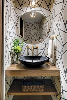 a bathroom sink with a black bowl on top of it next to a wooden counter