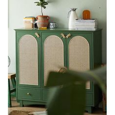 a green cabinet with wicker doors in a living room