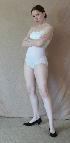 a woman in a white bodysuit posing for the camera