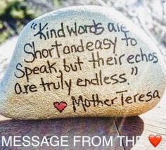 a rock with writing on it sitting on top of a wooden table