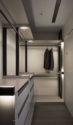 an empty walk - in closet with clothes hanging on the wall