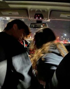 two people sitting in the back seat of a car