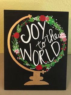 a black card with the words joy to the world on it and a gold circle