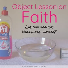 a bottle of liquid next to a glass bowl with water in it and an object on the table