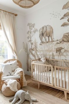 a baby's room with an elephant mural on the wall and a crib