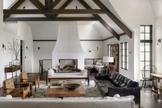 a living room filled with furniture and a fire place in the middle of an open floor plan