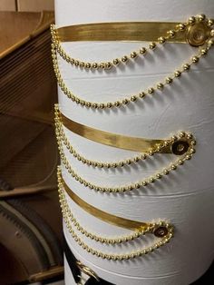 a white pillar with gold chains on it