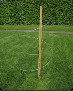 a wooden pole in the middle of a grassy area with a wire around it and two circles on each side