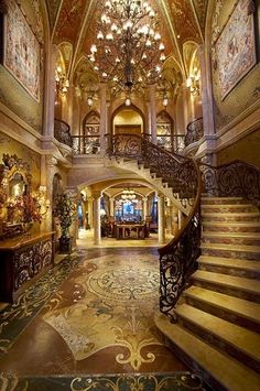 an ornately decorated foyer with chandelier and stairs