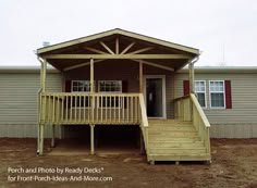 a mobile home with stairs leading up to the front door and second story porch area