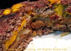 a close up of a sandwich on a plate with cheese and other food items in the background