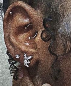 a close up of a person's ear with butterflies attached to the middle part