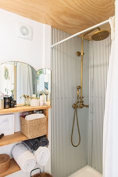 a bathroom with an open shower and wooden shelves