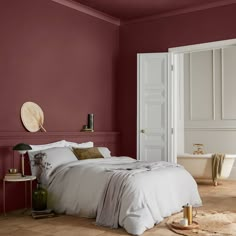 a bedroom with red walls and white bedding