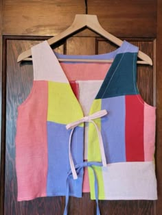 a multicolored top hanging on a door with a tie at the waist and bottom