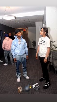 two young people standing in an office lobby with one person looking up at the ceiling