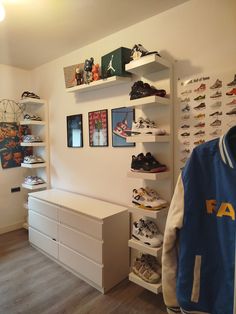 a room filled with lots of shoes on shelves next to a dresser and wall mounted pictures