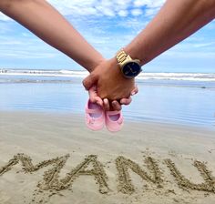 two people holding hands while standing in the sand at the beach with words written on it