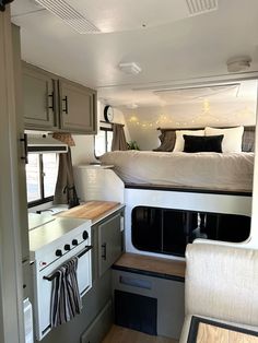 the interior of a camper with a bed, sink and stove