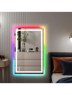 a bedroom with a bed, dresser and mirror that is lit up in different colors