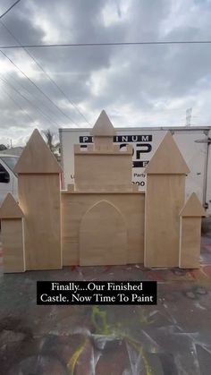 a large wooden gate in front of a building with the words finally our finished castle now time to paint