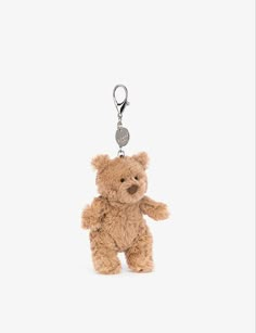 a small brown teddy bear with a tag on it's ear and a keychain