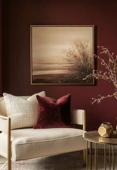 a living room filled with furniture and a painting hanging on the wall above a coffee table