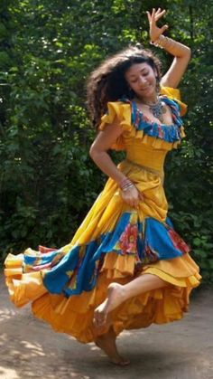 a woman in a yellow and blue dress dancing