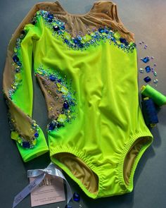 a neon green bodysuit with blue and gold beads on the side, next to a hairdryer