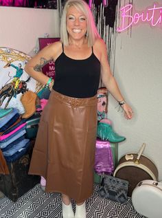 A staple, classic fashion piece with unlimited style potential. Brown vegan leather skirt. 60% rayon and 40% polyester Flattering A-line silhouette. Midi length skirt appropriate for any occasion. Elastic waist with a brown faux leather belt (included). True to size, approximately small 0-5. medium 5-10, large 10-12. Model is a size 10/11 wearing a large. Classic Fashion Pieces, Vegan Leather Skirt, Faux Leather Belts, Midi Length Skirts, Classic Fashion, Leather Belt, Midi Length, Leather Skirt, Vegan Leather