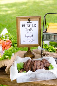 a burger bar with lettuce, tomatoes and other food items on the table