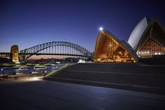 the sydney opera house is lit up at night