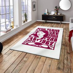 a living room area with hardwood floors and white rugs on top of the floor