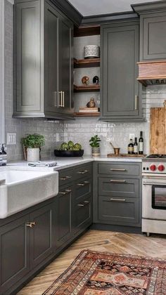 a kitchen with gray cabinets and white counter tops, an oven and sink in the center