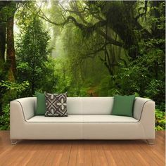 a couch sitting on top of a wooden floor in front of a forest wall mural