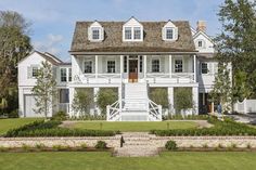 a large white house sitting on top of a lush green field