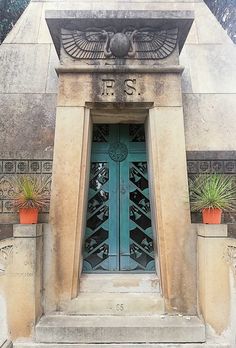 an entrance to a building with two potted plants on either side and the door